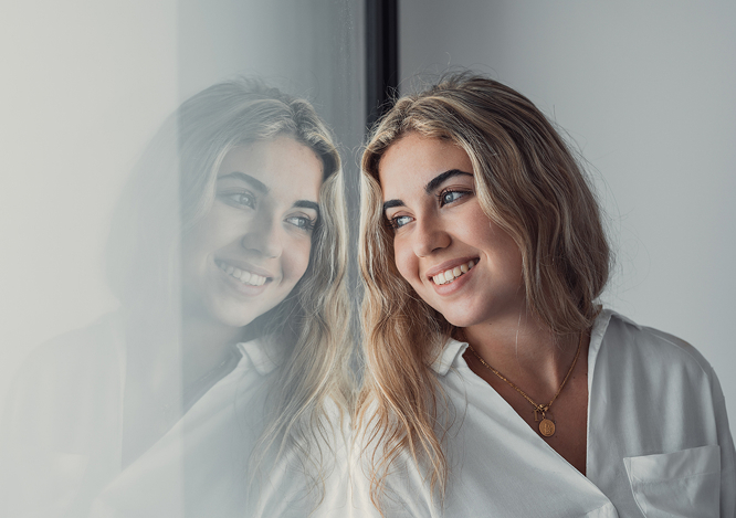 Blonde Woman Smiling Out Of A Window
