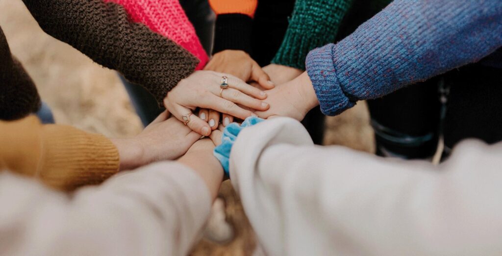 Close Up Of Group Of People In A Circle With Their Hands Together