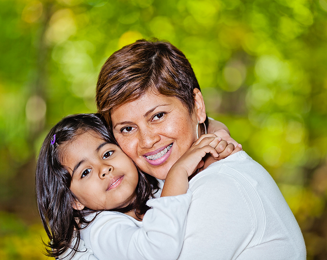 Latin American Mother With Braces Hugs Her Daughter In A Park