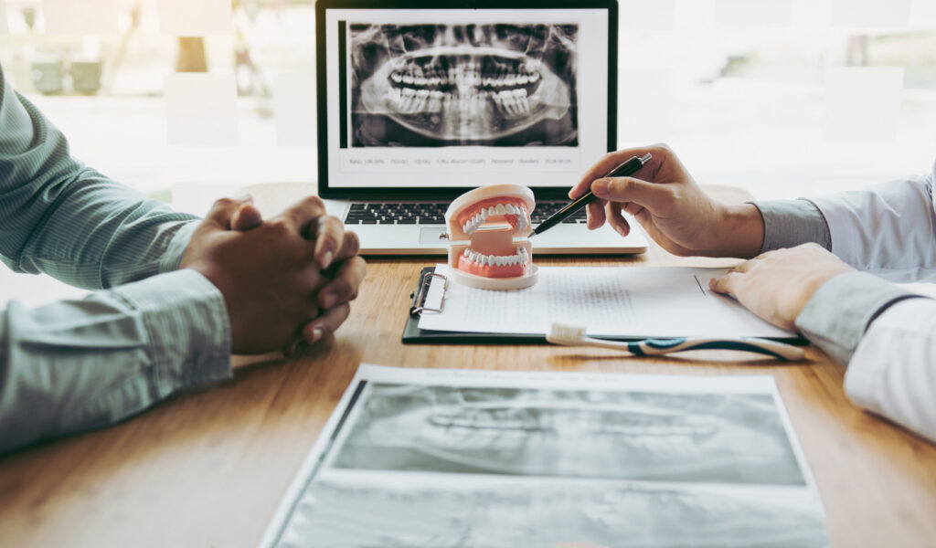 A Doctor Pointing At A Model Of Teeth
