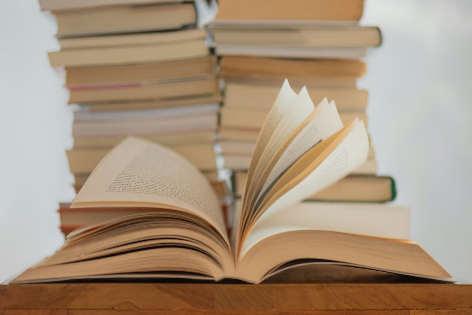 An Open Book In Front Of A Stack Of Books
