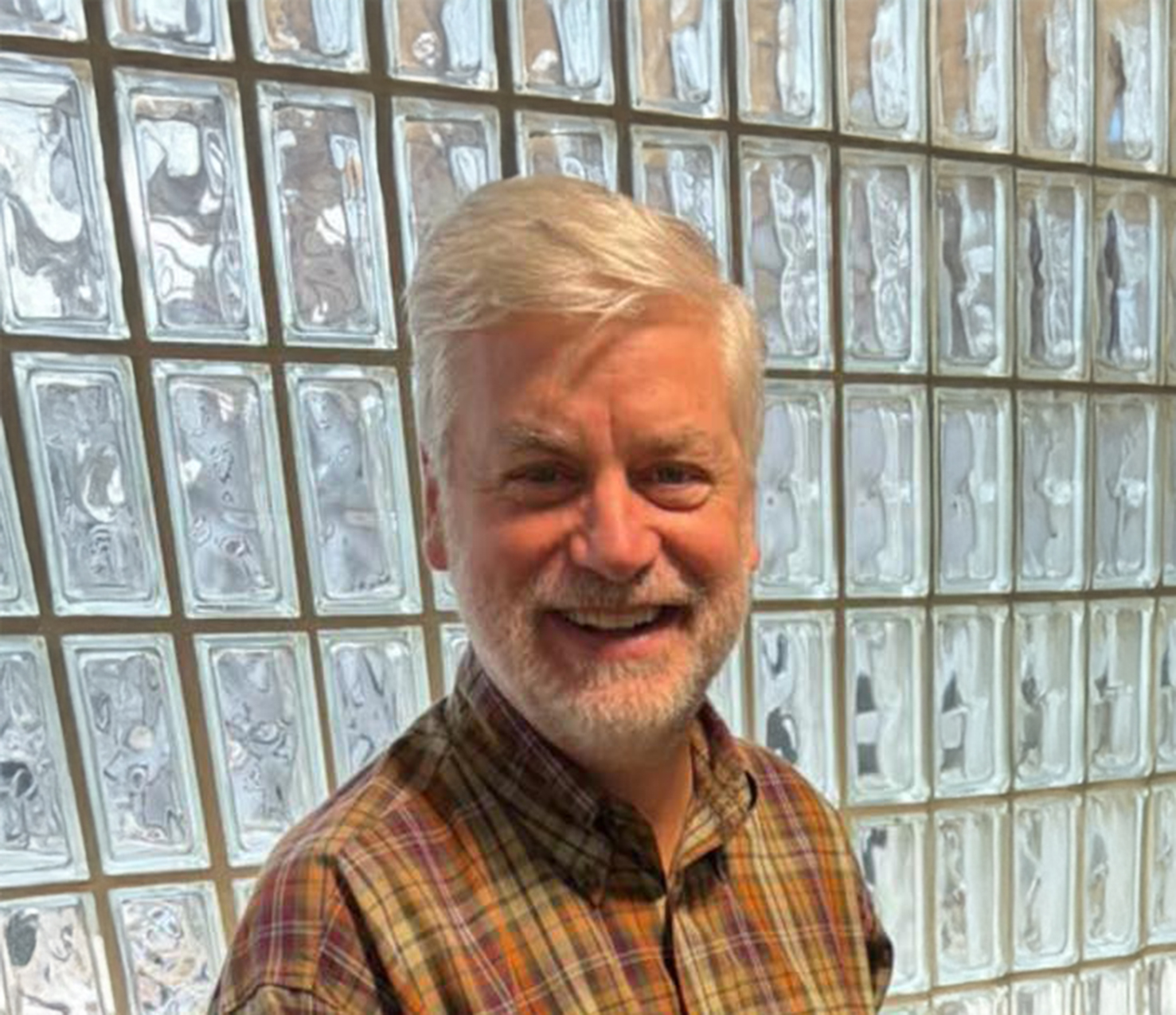 Dr Lang standing in front of a glass wall in the office.
