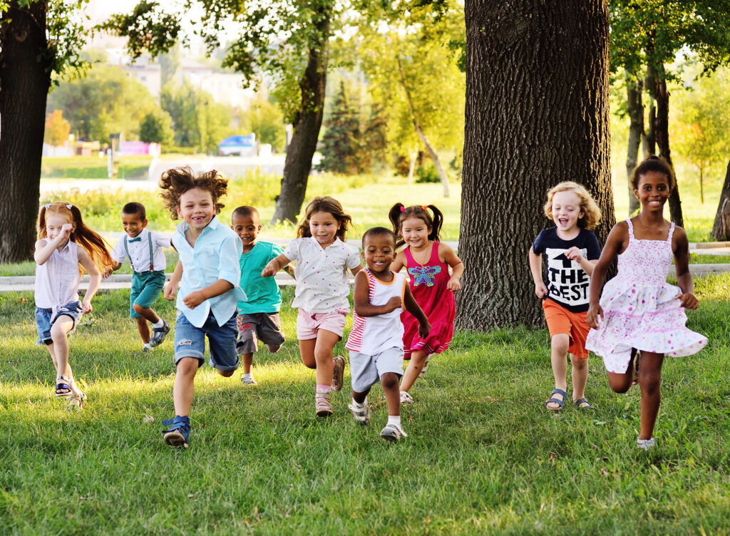 Kids Running And Playing In A Field Under A Tree