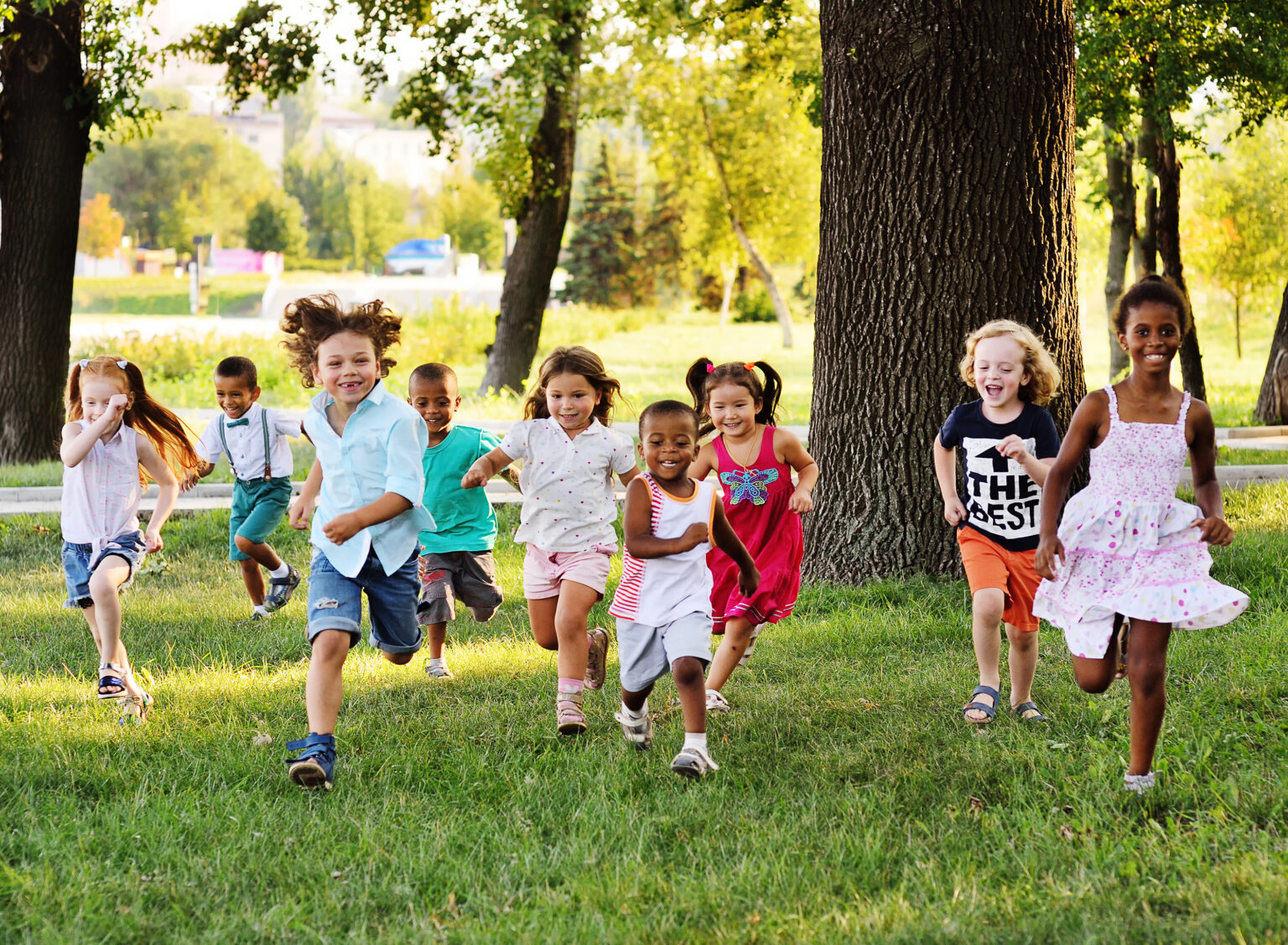 Kids Running And Playing In A Field Under A Tree