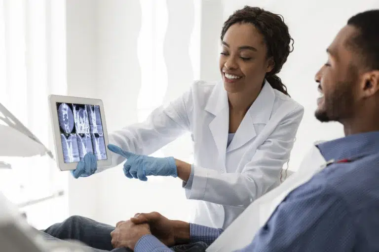 Smiling Female Dentist Showing Patient Teeth Xray
